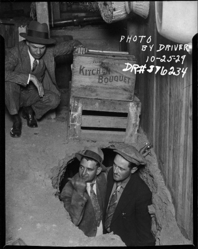 Driver.
Bootleg Raid. 3 Detectives on bootleg bust 2 coming out of the hole in the ground.
25.10.1929. 
Gelatin silver print.
Courtesy Fototeka Los Angeles
