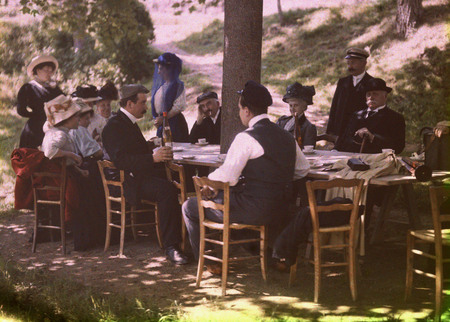 Братья Люмьер.
Люмьеры: семейный обед. 
1910. 
Луи Люмьер – сидит у дерева, Огюст (в фуражке) – стоит возле стола. 
© Institut Lumiere, Famille Lumiere