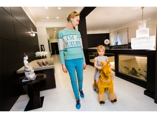 © Lauren Greenfield. 
Ilona at home with her daughter, Michelle, 4, Moscow, 2012.
Ilona’s sweater was produced for her in a custom color by her friend Andrey Artyomov, Walk of Shame fashion line founder.<br />
Credit: Lauren Greenfield/INSTITUTE