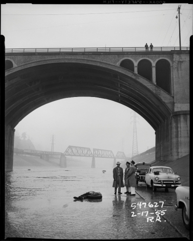 Р. Риттенхаус.
Мост над рекой Лос-Анджелес. В реке мертвое тело, на мосту полицейский детектив, а в стороне машина.
17.02.1955.
Серебряно-желатиновый отпечаток.
Предоставлено Фототекой Лос-Анджелеса