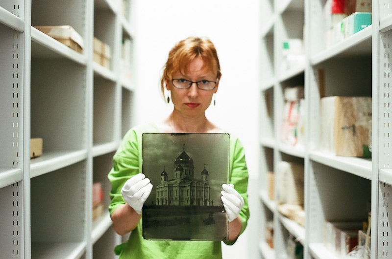 Anna Razina holds a glass negative more than one hundred years old. It is now a positive image due to chemical reactions